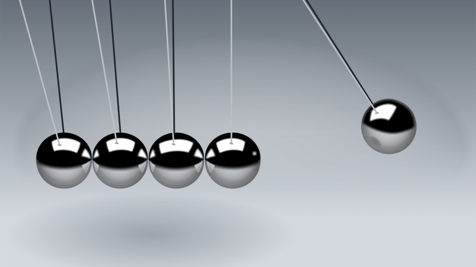 Newton's cradle with five metallic balls in motion, demonstrating principles of physics and momentum.