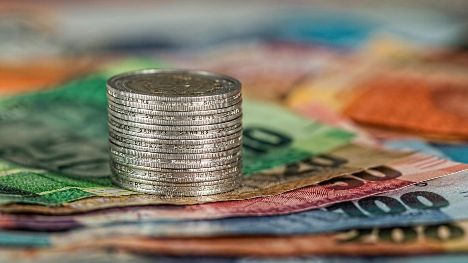 R5 coins stacked on top of South African Rand notes